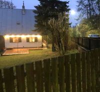 A family house in Horné Otrokovce on Horné Otrokovce Street with a lit terrace and gate.