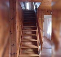 Wooden stairs lead to the upper floor in a family house with a wooden decor floor.