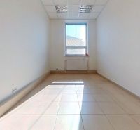 A bright office with a tiled floor and a large window letting in light.