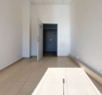The interior of an office with white walls and light ceramic floor tiles.
