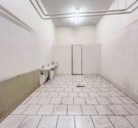 Interiors of warehouses and halls with white walls, two sinks, and tiled flooring.