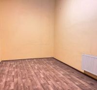 A room with a wooden decor floor, yellow walls, and a radiator in warehouses and halls.