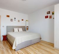 Bright bedroom in a 3-room apartment with a bed and wood-decor flooring.