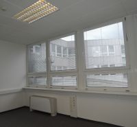 Offices with large windows and blinds, white walls, and gray carpet.