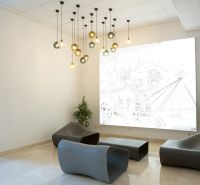 Offices with modern seating, pendant lights, and a decorative wall panel.
