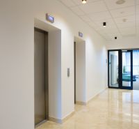 In the offices, you can see a hallway with elevators and light marble flooring.