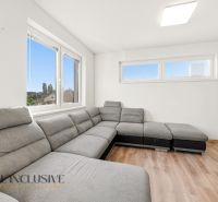 A bright living room with a corner sofa and a wooden decor floor in a 3-room apartment.