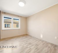 A bright room in a 3-room apartment with a wood-patterned floor and white walls.