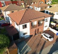 In Dunajská Streda, modern houses with a parking lot in front of the entrance are displayed.