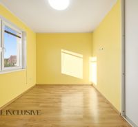Interior of a 3-room apartment with yellow walls and a floor with a wooden decor.