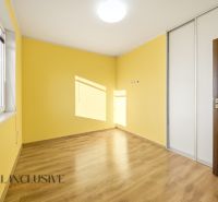 Yellow room in a 3-room apartment with a wooden decor floor and a built-in wardrobe.