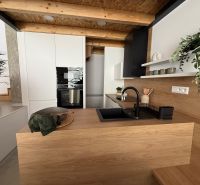 Modern kitchen in a family house with wood decor and a black sink.