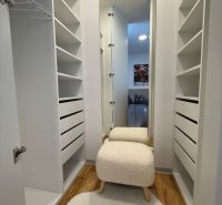 Family house with a wardrobe, wooden decor flooring, and a comfortable chair.