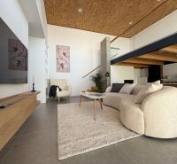 Living room in a family house with a comfortable sofa and decorative paintings on the wall.