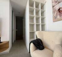 Armchair, storage shelf, and painting in the interior of a family house with floor decor.