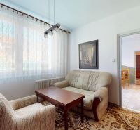 A sofa set and an armchair with a carpet in a 3-room apartment, a painting on the wall.