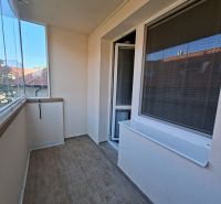 Glazed balcony in a 3-room apartment, wood-effect tiles, pleasant lighting.