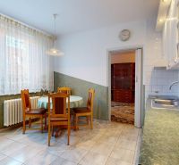 A kitchen in a 3-room apartment with a dining table, chairs, and a kitchen unit.