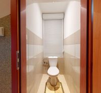 A bathroom in a 3-room apartment with combined tiles and a roller window.