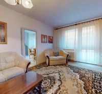 Living room in a 3-room apartment with a comfortable sofa and a view through large windows.