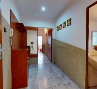 A hallway in a 3-room apartment with tiles and a cozy living space.