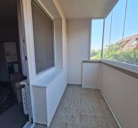 Glazed loggia with tiles in a 3-room apartment, next to living spaces.