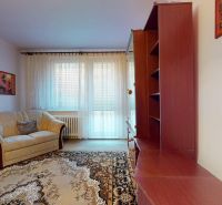 Living room in a three-room apartment with a sofa, furniture, and a large window.