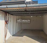 An empty garage in Senec with a roof and white walls.