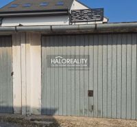 Garages in Senec with metal gates and a building roof.