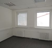 Offices with white walls, carpet, and two windows, radiators under the windows.