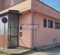 The exterior of an office building in Senec with a no parking sign and metal doors.