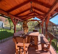 The terrace of the cottage in Turík, Ružomberok district with wooden furniture and a bear statue.