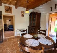 A dining table and a display cabinet made of dark wood in a cozy cabin.