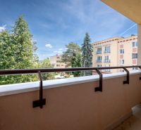View from the balcony of a 3-room apartment on Švermova Street in Trenčín overlooking greenery and buildings.