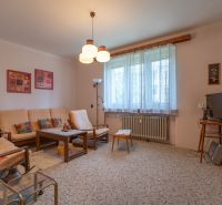 A living room in a 3-room apartment with classic furniture and a carpet, light walls.