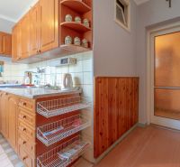 A kitchen with cabinets and basket shelves in a 3-room apartment, a floor with a wooden decor.