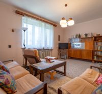 Living room in a 3-room apartment with retro furniture, a sofa, and a bookshelf.