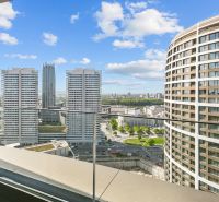 View from the balcony on Továrenská Street with modern high-rise buildings and an urban landscape.