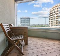 The balcony of a 3-room apartment on Továrenská Street with a view of the city and modern buildings.