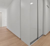 A spacious hallway with a built-in wardrobe in a 3-room apartment on Továrenská Street.