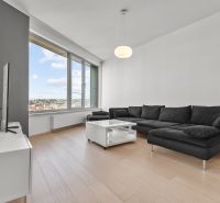 Bright living room on Továrenská Street in a 3-room apartment with a large window and a sofa.