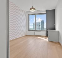 A bright room in a 3-room apartment on Továrenská Street with a view of modern architecture.