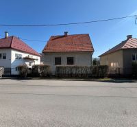 A family house in Banská Bystrica with a red roof and a hedge.