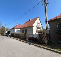 Family house in Podháj, Kráľová, Banská Bystrica. Narrow sidewalk, bushes, electric pole.
