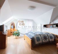Bedroom in a family house with a wood-patterned floor, a bed, and decorations.
