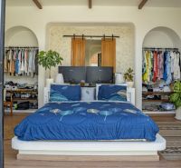 Bedroom in a villa with a wardrobe, bed, and floor with wooden decor.