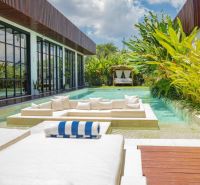 Villa in Bali with a pool, relaxing seating area, and lush tropical garden.
