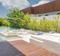 Luxury villa in Bali with a pool surrounded by greenery and a relaxation zone.