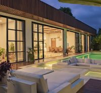 Villa in Bali with a pool and a terrace with wood-patterned flooring.