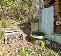 Wooden structure of the cottage and a rain barrel in the garden on 1st May Street, Krásna.